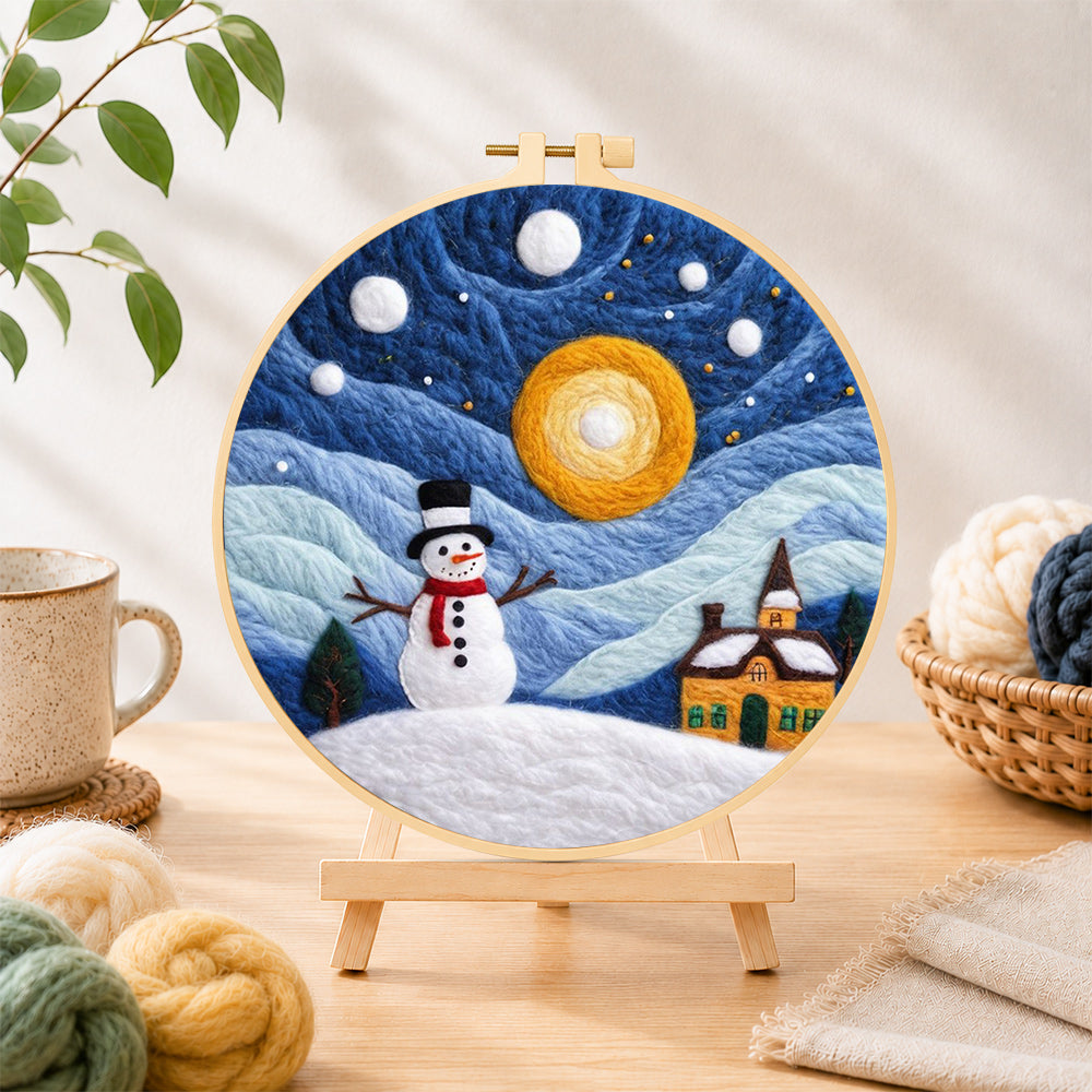 Finished snowman and swirling starry night sky needle felting displayed on a wooden easel