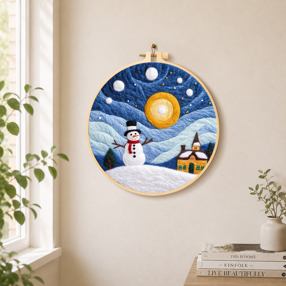 Snowman and swirling starry night sky needle felt wall art displayed in a bright home interior