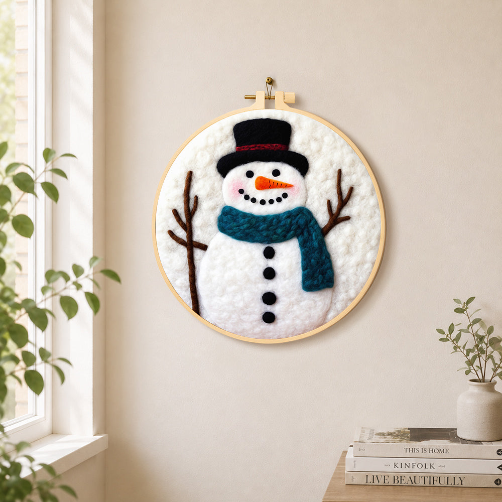 Snowman with teal scarf needle felt wall art displayed in a bright home interior