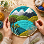 Creating the snowy mountains and summer hills wool painting by hand with a felting needle