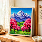 Snowy peaks and pink sakura trees punch needle artwork displayed on a table