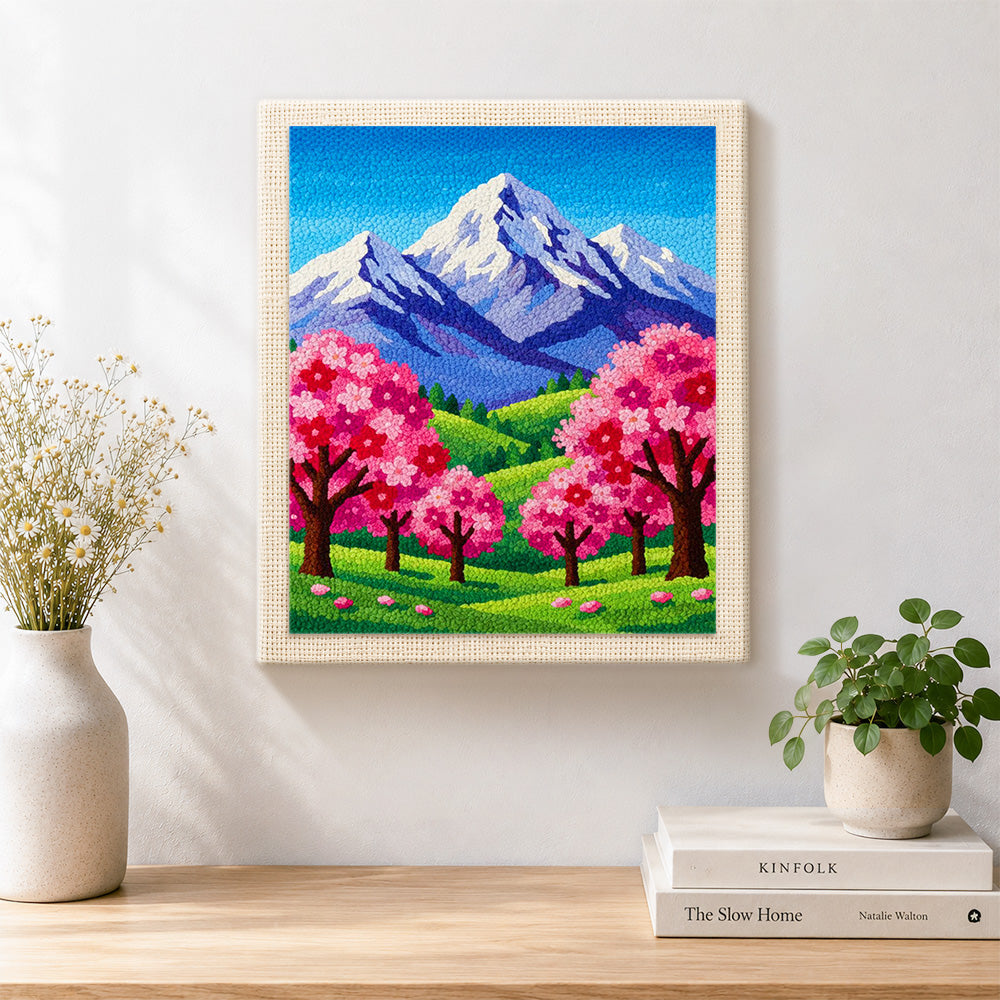 Finished snowy peaks and pink sakura trees artwork displayed on a wall