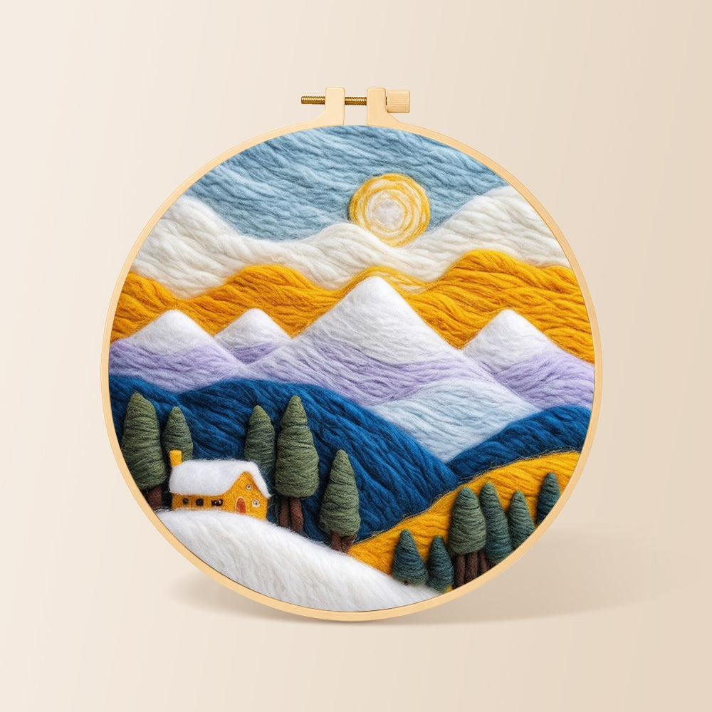 Snowy peaks and yellow cottage with trees needle felting kit for beginners with a round wooden frame