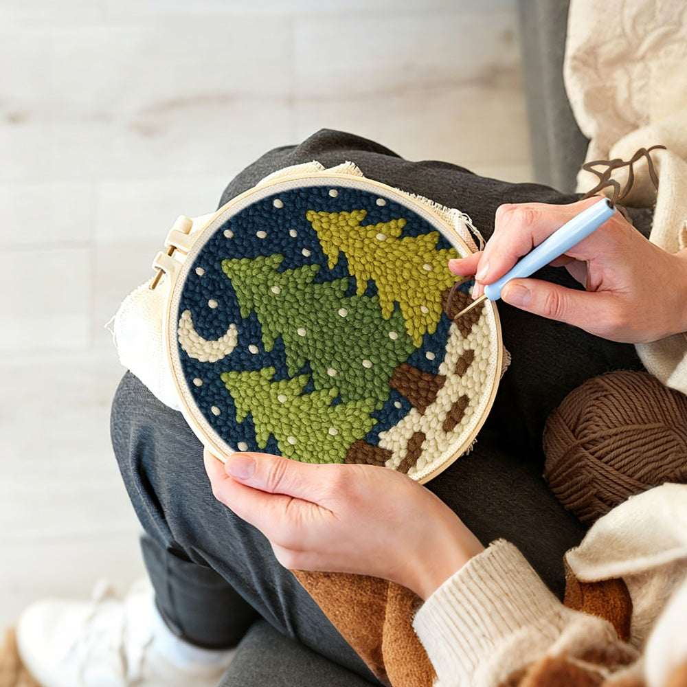 Creating handmade snowy pine trees and crescent moon punch needle artwork