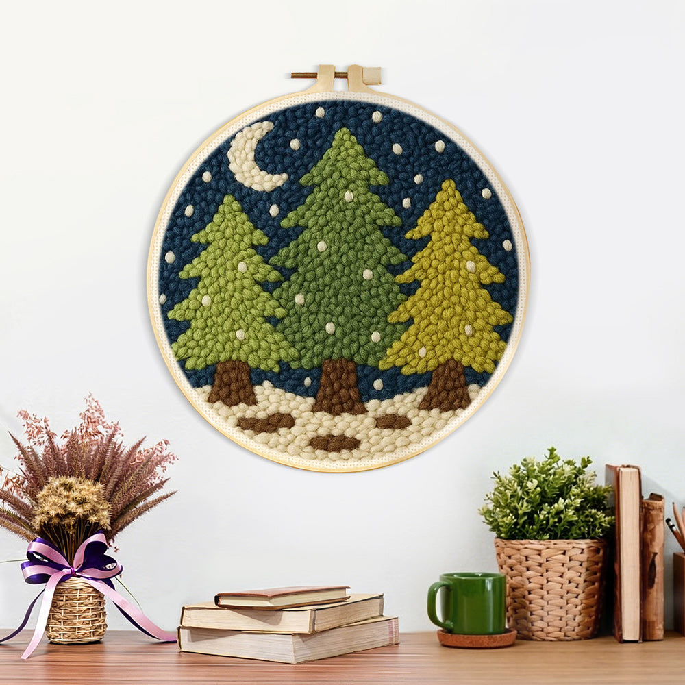 Finished snowy pine trees and crescent moon artwork displayed on a wall