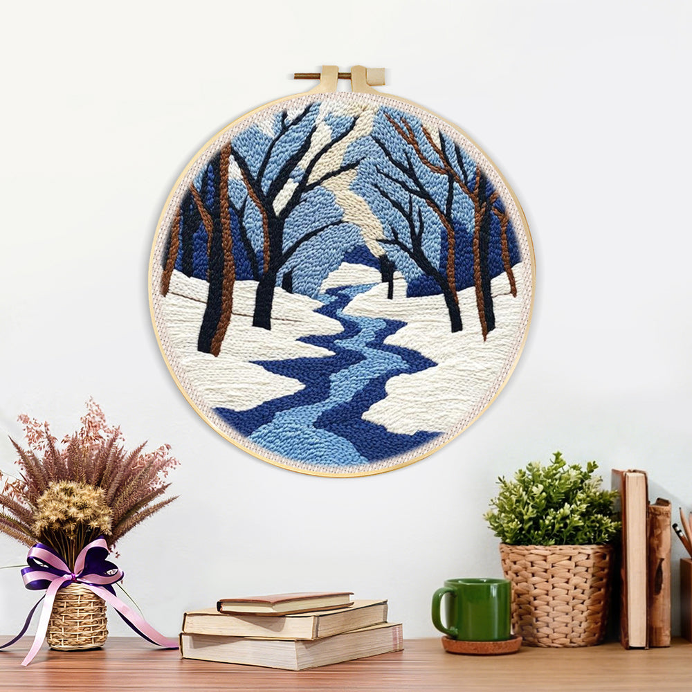 Finished snowy river landscape with bare trees artwork displayed on a wall