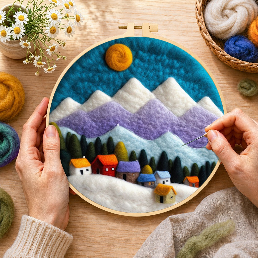 Creating the snowy village under the mountains wool painting by hand with a felting needle