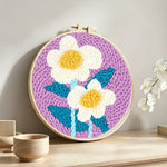 Soft white flowers punch needle artwork displayed on a table