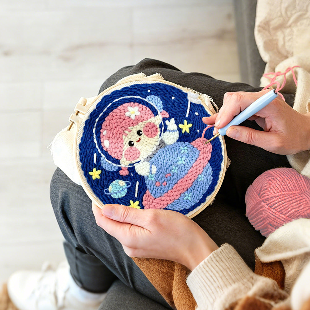 Creating handmade space girl sitting on a planet punch needle artwork