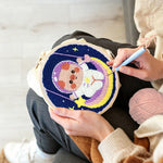 Creating handmade space piggy on rainbow swing punch needle artwork