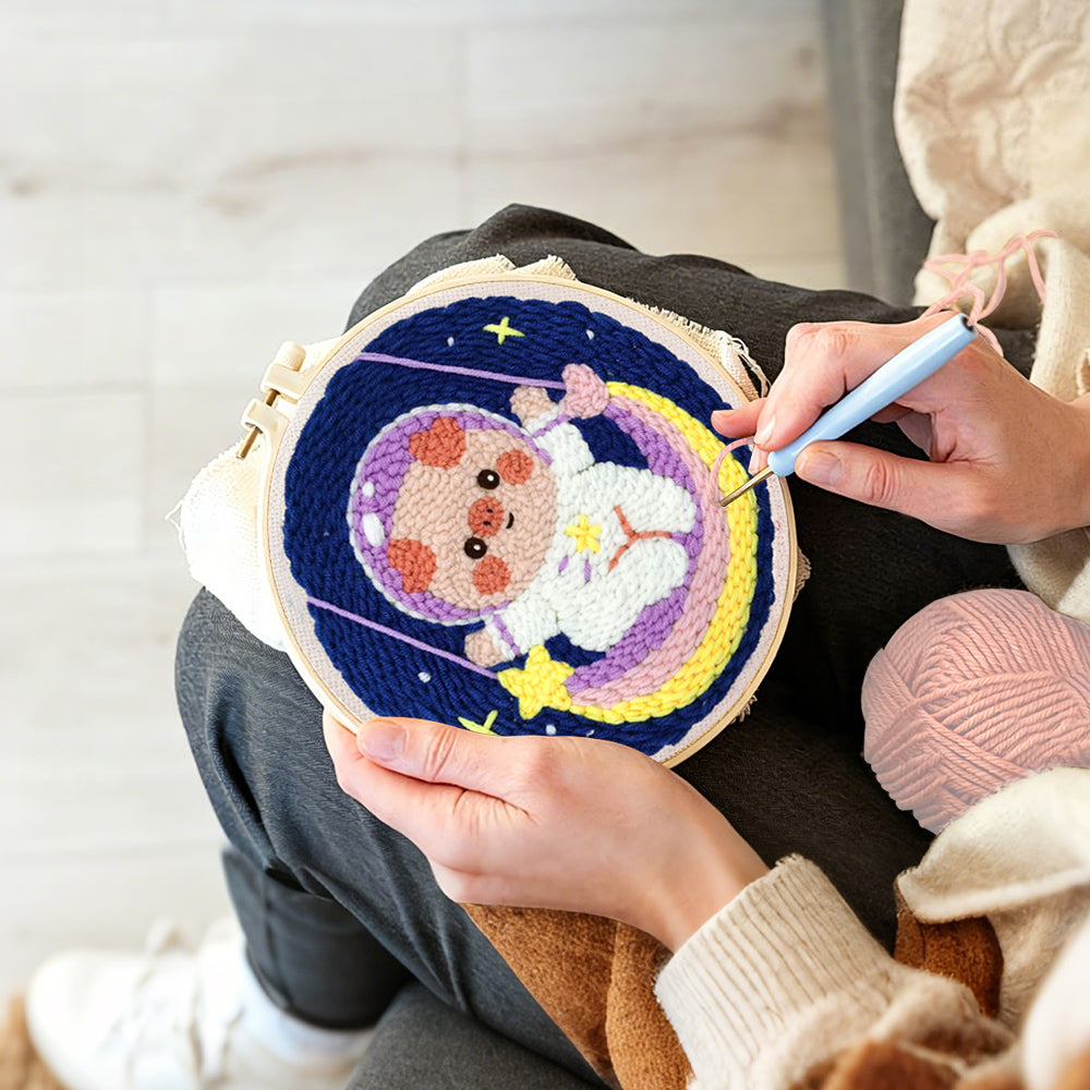 Creating handmade space piggy on rainbow swing punch needle artwork