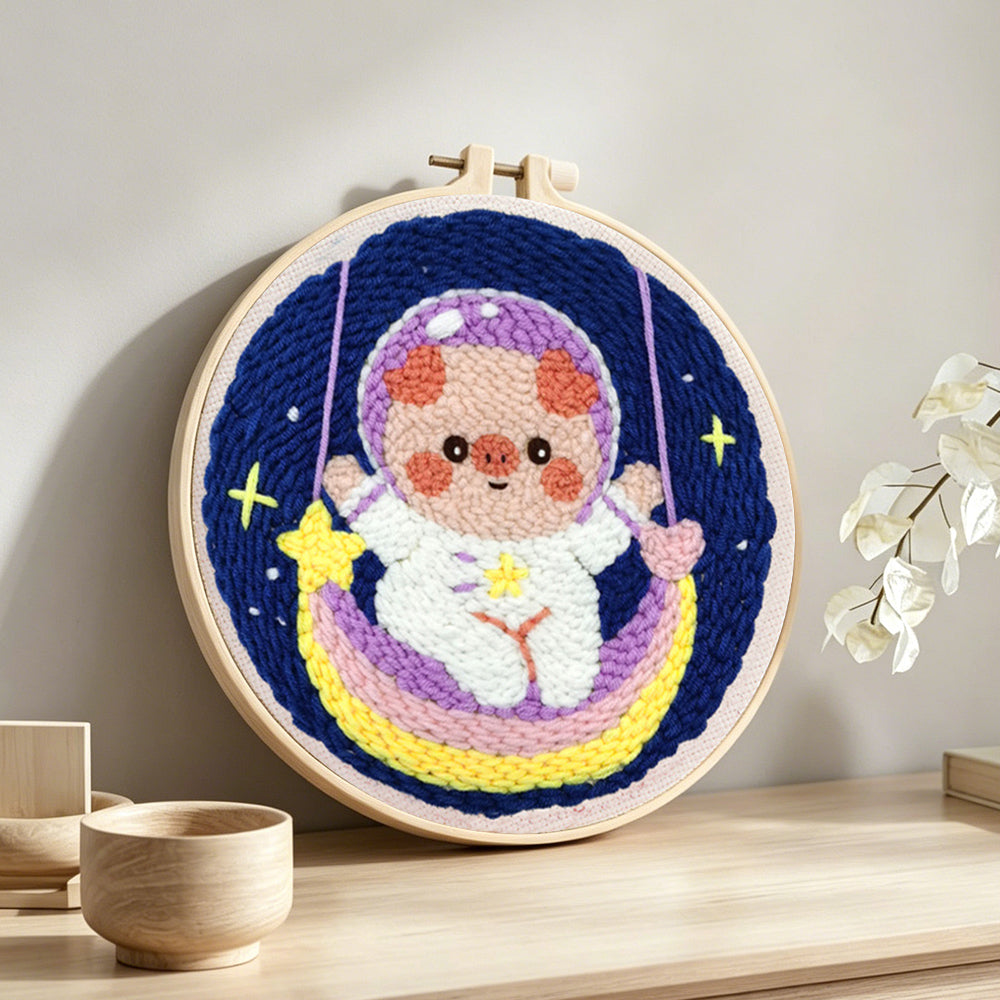 Space piggy on rainbow swing punch needle artwork displayed on a table
