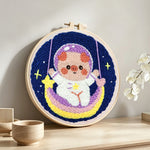 Space piggy on rainbow swing punch needle artwork displayed on a table