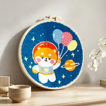 Space puppy with balloons punch needle artwork displayed on a table
