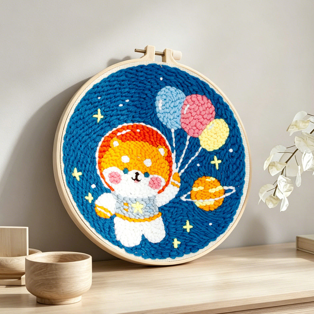 Space puppy with balloons punch needle artwork displayed on a table