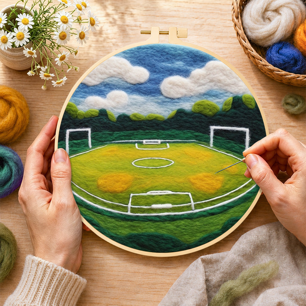 Creating the spacious football pitch wool painting by hand with a felting needle