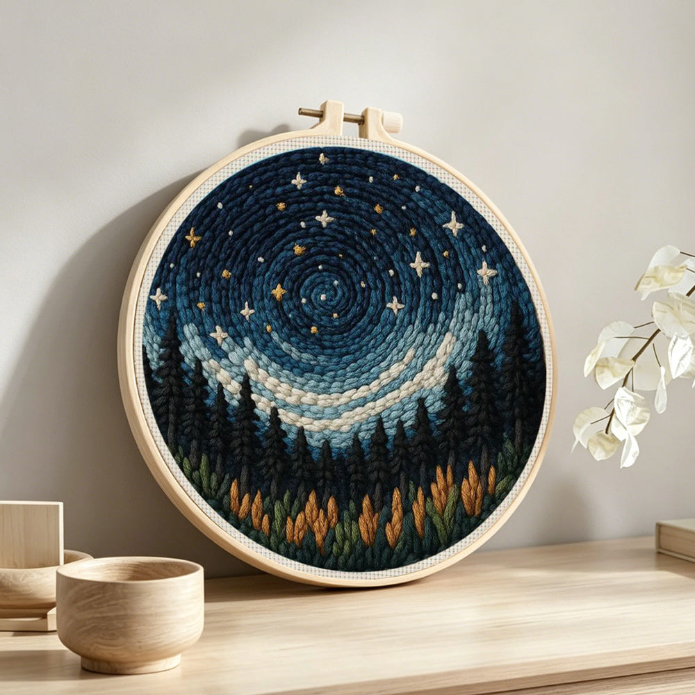 Spiral blue starry sky and black forest punch needle artwork displayed on a table