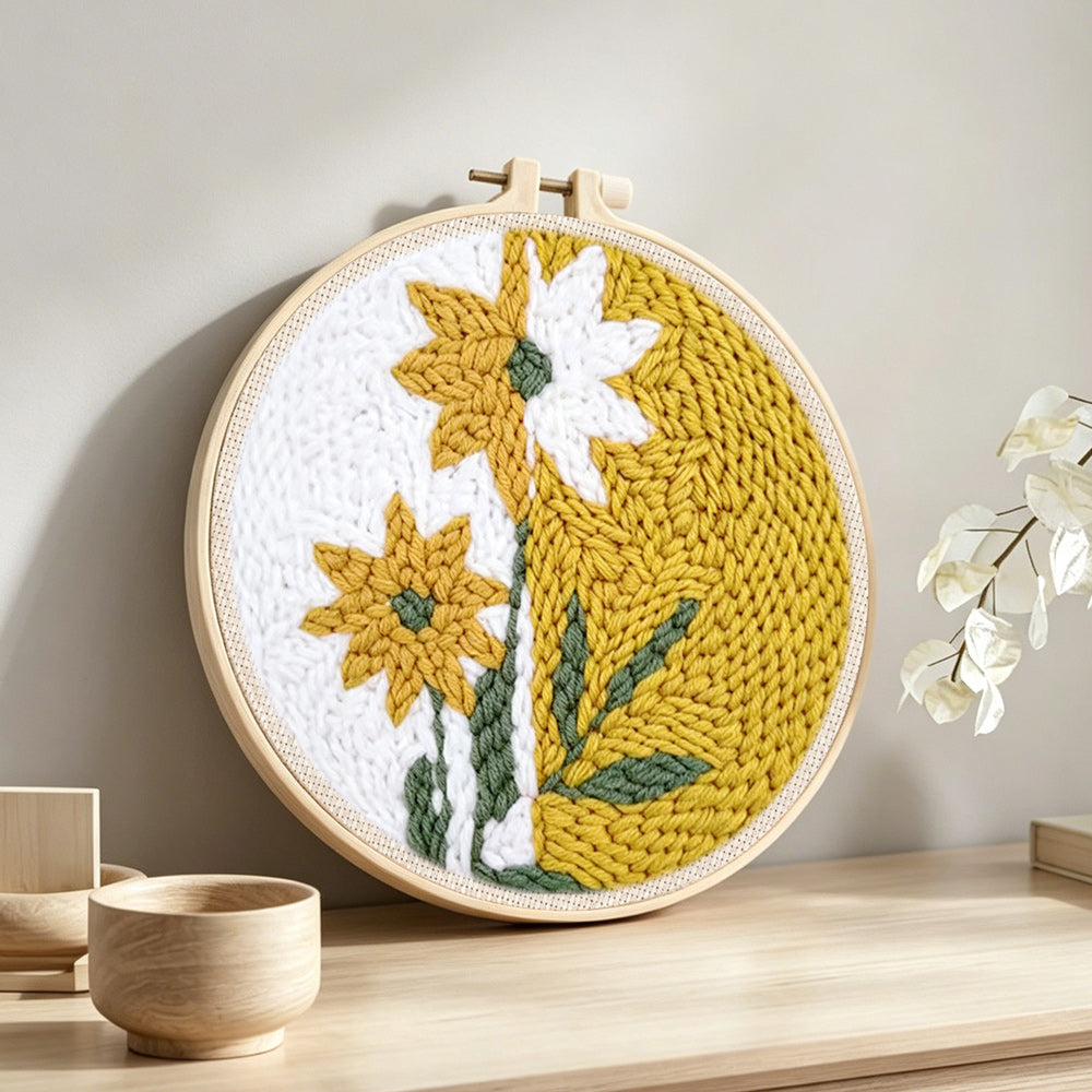Split-tone dandelion flower punch needle artwork displayed on a table