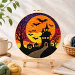 Finished spooky orange moon and bat castle needle felting displayed on a wooden easel