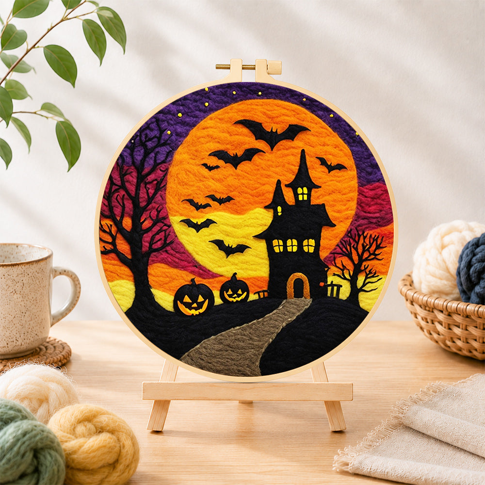 Finished spooky orange moon and bat castle needle felting displayed on a wooden easel