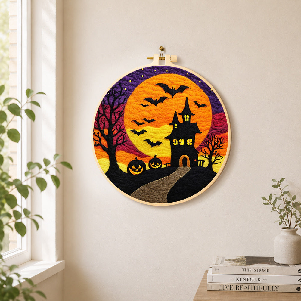 Spooky orange moon and bat castle needle felt wall art displayed in a bright home interior