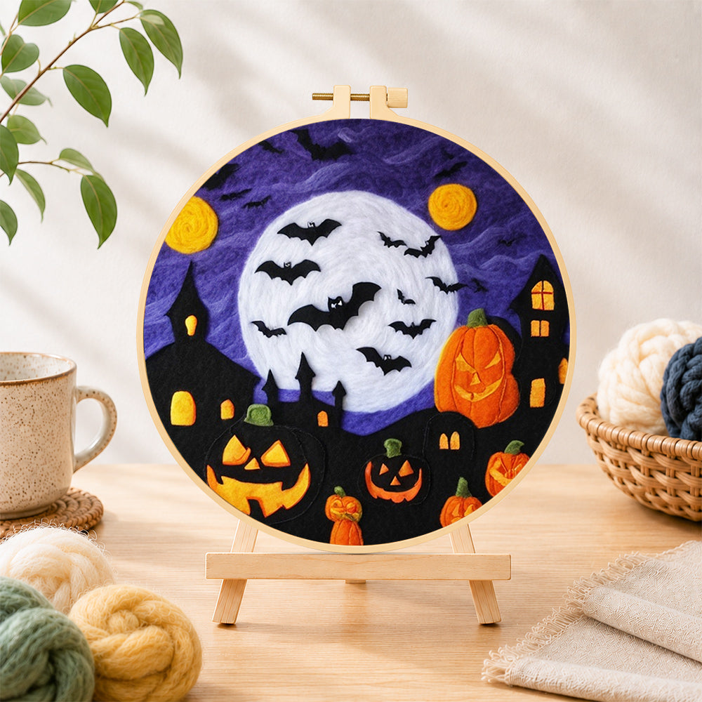 Finished spooky white moon and bat swarm needle felting displayed on a wooden easel