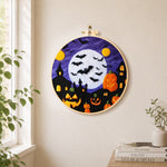 Spooky white moon and bat swarm needle felt wall art displayed in a bright home interior