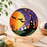 Finished spooky yellow moon and bare trees needle felting displayed on a wooden easel