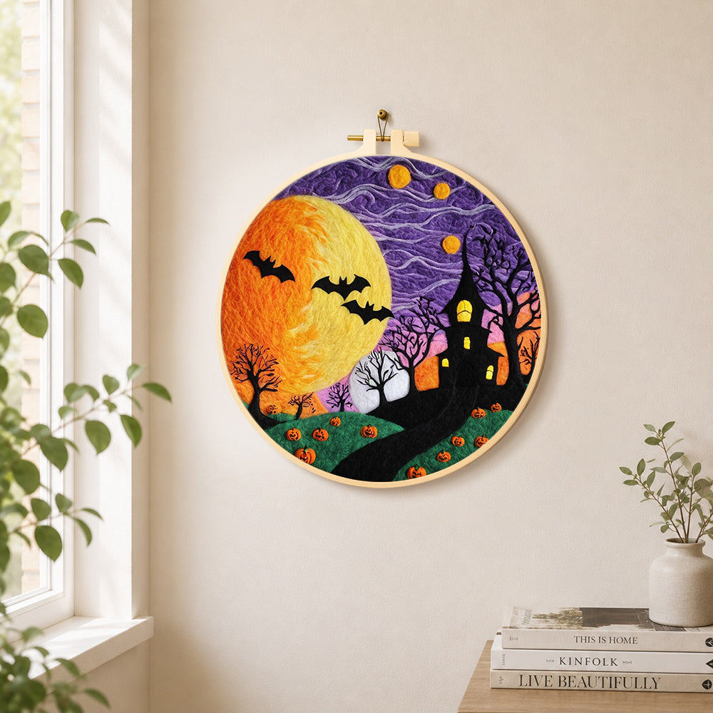 Spooky yellow moon and bare trees needle felt wall art displayed in a bright home interior