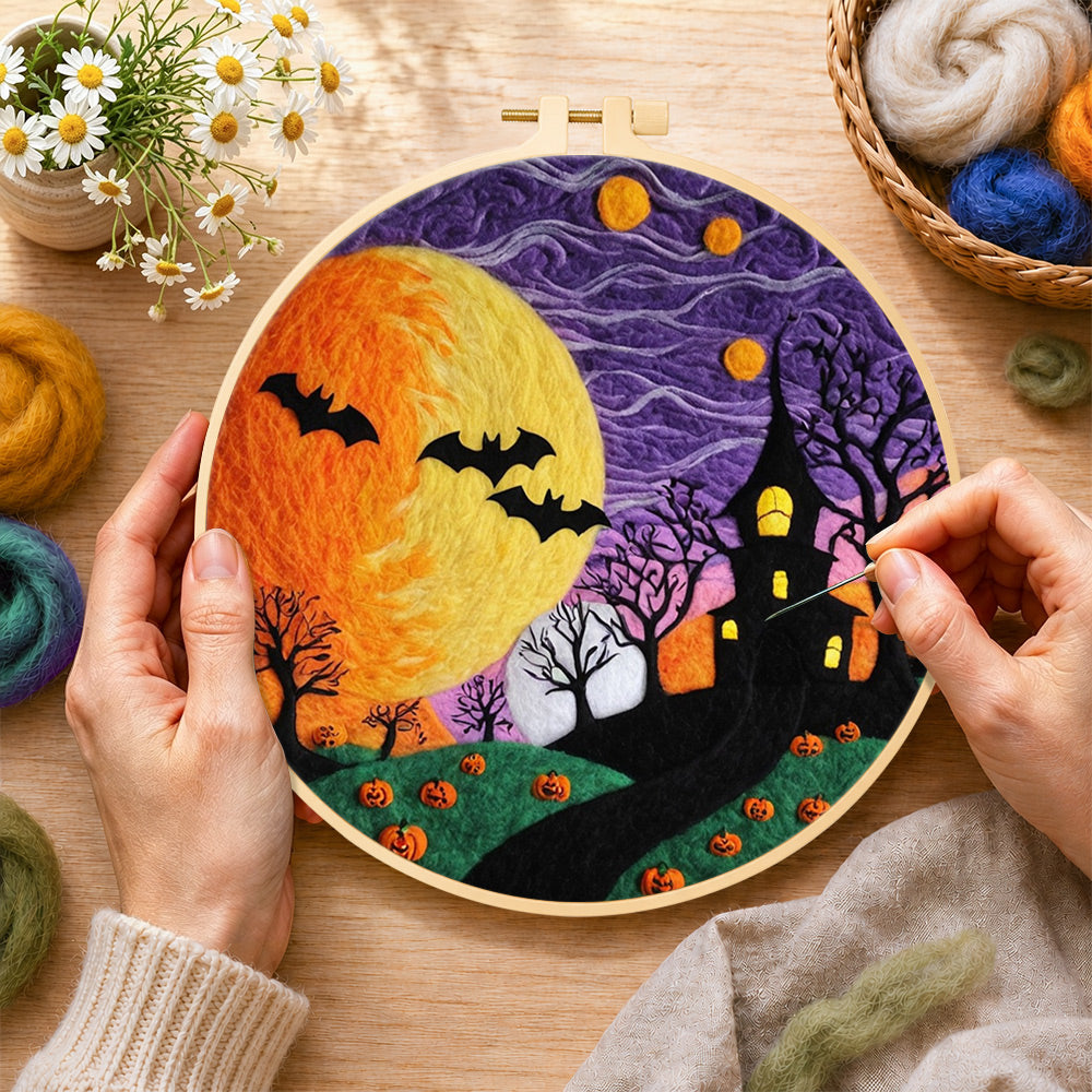 Creating the spooky yellow moon and bare trees wool painting by hand with a felting needle
