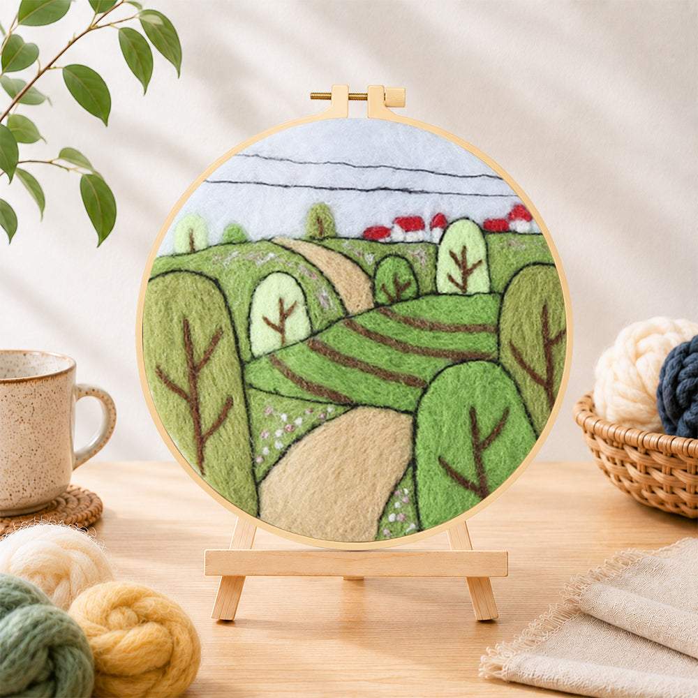 Finished spring fields with green trees needle felting displayed on a wooden easel