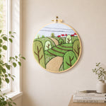 Spring fields with green trees needle felt wall art displayed in a bright home interior