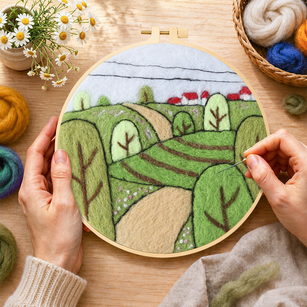 Creating the spring fields with green trees wool painting by hand with a felting needle