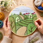 Creating the spring fields with green trees wool painting by hand with a felting needle