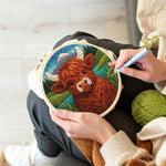Creating handmade springtime highland cow and mountain lake punch needle artwork