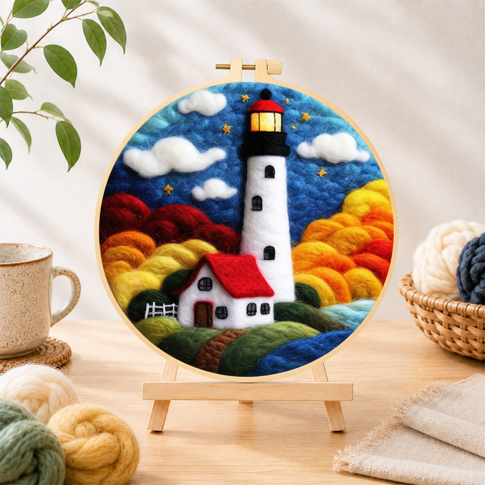 Finished starry night lighthouse and cottage needle felting displayed on a wooden easel