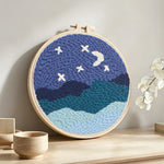 Starry night sky over mountains punch needle artwork displayed on a table