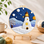 Finished starry night snowy lighthouse needle felting displayed on a wooden easel