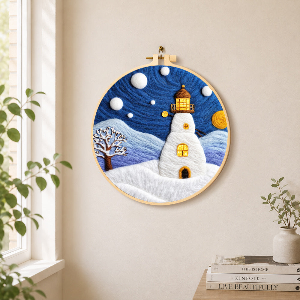 Starry night snowy lighthouse needle felt wall art displayed in a bright home interior