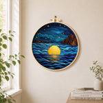 Starry ocean and golden full moon needle felt wall art displayed in a bright home interior