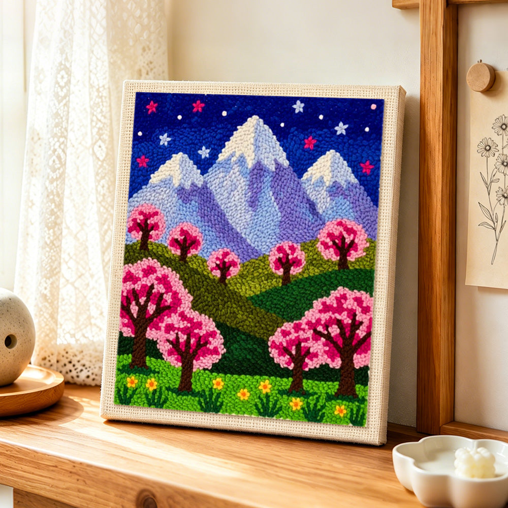 Starry sakura mountain at night punch needle artwork displayed on a table