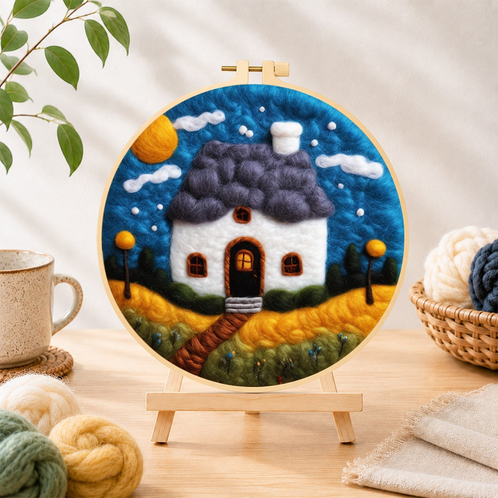 Finished starry sky and blue roof cottage needle felting displayed on a wooden easel