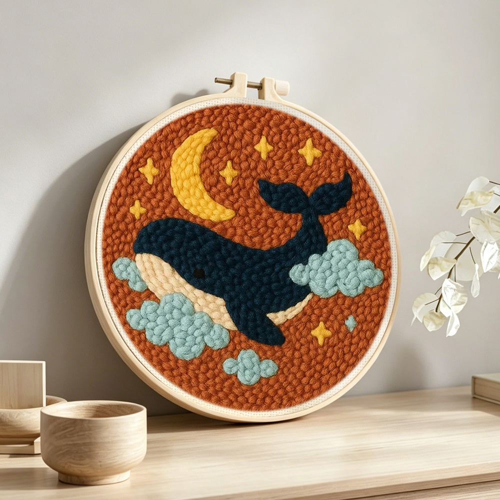 Starry whale punch needle artwork displayed on a table