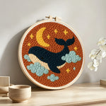 Starry whale punch needle artwork displayed on a table