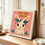 "Stay playful" bunny punch needle artwork displayed on a table