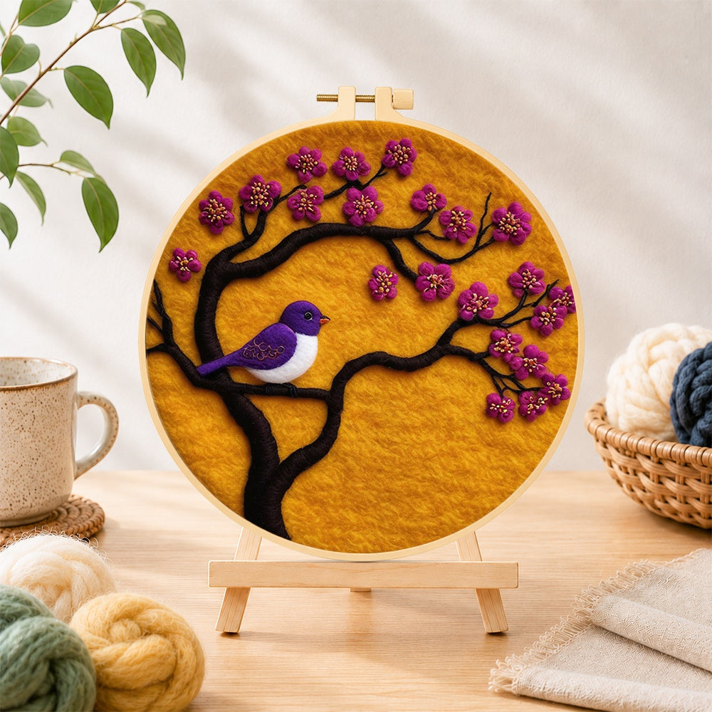 Finished striking purple bird on blooming branch needle felting displayed on a wooden easel