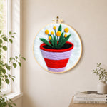 Striped pot with yellow flowers needle felt wall art displayed in a bright home interior