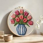 Striped vase with pink tulips punch needle artwork displayed on a table
