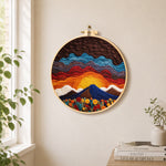 Stunning sunrise over wavy hills needle felt wall art displayed in a bright home interior