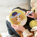 Creating handmade stylised girl in blue bucket hat punch needle artwork